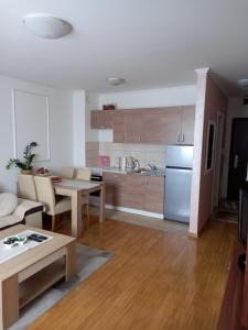 a kitchen and living room with a table and a refrigerator at Apartman Jana in Doboj
