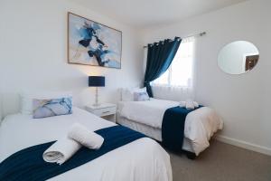 une chambre avec deux lits et un miroir dans l'établissement 1401 Hibernian Towers Luxury Self Catering Apartment Strand Western Cape South Africa, au Cap 29 autres photos