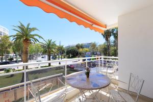 a balcony with a table and chairs and palm trees at Rhin Apartment - PlanetCostaDorada in Salou