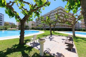 a park with a pool and trees and a building at Rhin Apartment - PlanetCostaDorada in Salou