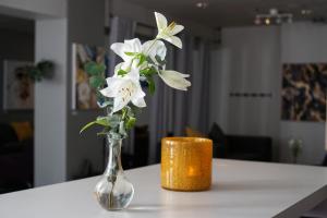 wazon wypełniony białymi kwiatami siedzącymi na stole w obiekcie Comfort Hotel Helsingborg w mieście Helsingborg
