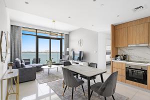 Una cocina y una sala de estar con mesa y sillas. en Seaside Serenity: 1-BR Apartment with Beach Access, en Dubái