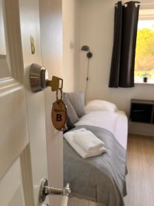 ein Zimmer mit einem Bett und einer Tür mit einem Hausschild in der Unterkunft Munkgaard INN & OUTDOOR in Rødvig + 29 Fotos