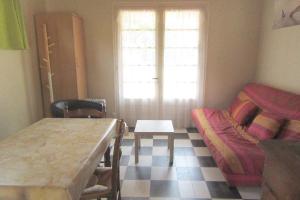 ein Wohnzimmer mit einem Tisch und einem Sofa in der Unterkunft Pétrouchka dans les pins in Saint-Hilaire-de-Riez