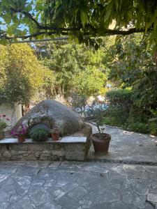 una panchina di pietra con piante in vaso in un giardino di Vasilion Agrotourism a Polis Chrysochous