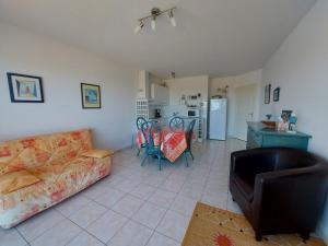a living room with a couch and a kitchen at La baie de Sion in Saint-Hilaire-de-Riez