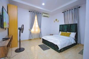 a bedroom with a bed and a television in it at Treasurablehomes in Maiyegun