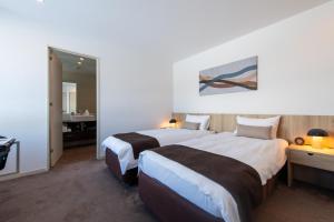 a hotel room with two beds and a bathroom at The Freshwater in Kutchan