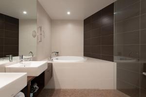 uma casa de banho branca com 2 lavatórios e um chuveiro em The Freshwater em Niseko