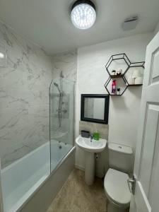 ein Badezimmer mit einem Waschbecken, einer Badewanne und einem WC in der Unterkunft MK Apartments South MCR, Chorlton in Manchester