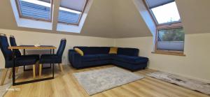 a living room with a blue couch and a table at Apartament ENKLAVA in Tylicz