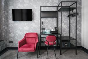 - une chambre avec un bureau et une chaise rouge dans l'établissement Krisotel, à Amsterdam