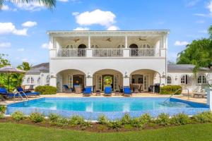a large white house with a swimming pool at Royal Westmoreland, Mahogany Drive 7 by Island Villas in Saint James