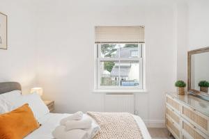 a white bedroom with a bed and a window at Little Estura in Uny Lelant