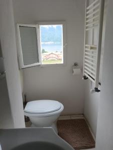 een witte badkamer met een toilet en een raam bij casa del sole Ossuccio in Como