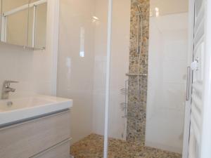 ein weißes Badezimmer mit Dusche und Waschbecken in der Unterkunft L'estivant sur l'océan in Saint-Hilaire-de-Riez + 10 Fotos