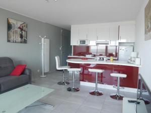 eine Küche mit einem Sofa und eine Kücheninsel mit Barhockern in der Unterkunft L'estivant sur l'océan in Saint-Hilaire-de-Riez