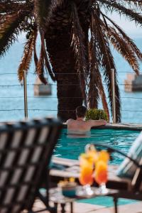 a man in a swimming pool next to a palm tree at Courtyard Hotel Gqeberha in Port Elizabeth