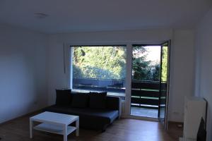 ein Wohnzimmer mit einem schwarzen Sofa und einem Tisch in der Unterkunft Zweites Zuhause in Recklinghausen