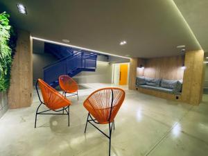 dwa pomarańczowe krzesła i kanapa w pokoju w obiekcie Sun Smart Hotel - w mieście Recife