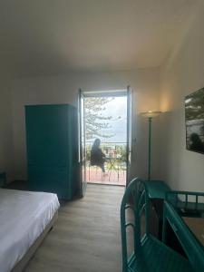 1 dormitorio con 1 cama y puerta que da a un patio en Hotel Baia Delle Sirene, en Taormina