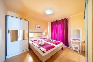 1 dormitorio con 1 cama grande y cortinas rosas en Guesthouse Mira, en Rab