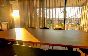 a wooden table with chairs in front of a window at Apartamento Con Jardín Rodeado de Viñedos in Ribadumia