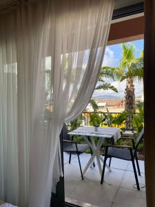 a balcony with white curtains and a table and chairs at KUCA URLA in Urla