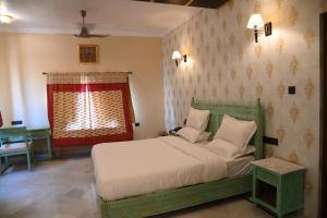 een slaapkamer met een groen bed en een raam bij K D PALACE HOTEL in Jaisalmer