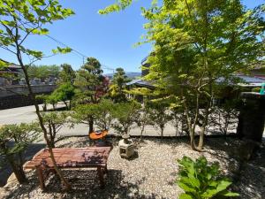 高山市にあるゲストハウス高山　半山舎の木の植えられた庭に座る公園ベンチ
