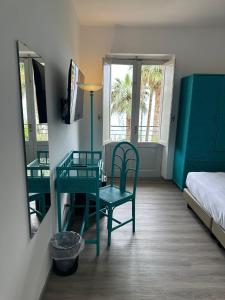 una camera da letto con scrivania, letto, tavolo e sedia di Hotel Baia Delle Sirene a Taormina