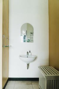 Sumanas Homestay Ijen في بانيووانجى: حمام مع حوض ومرآة على الحائط