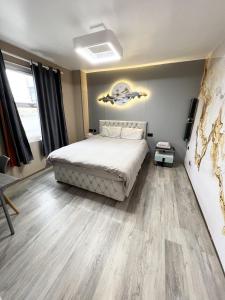 a bedroom with a bed and wooden floors at The Modern Space - New Renovation! in Pembrokeshire