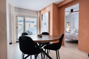 een eetkamer met een houten tafel en zwarte stoelen bij Apartment with terrace steps from beach REMS in Fuengirola