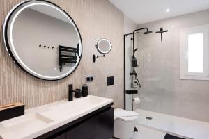 een badkamer met een witte wastafel en een spiegel bij Apartment with terrace steps from beach REMS in Fuengirola +26 foto's