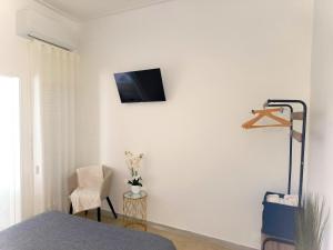 um quarto com uma televisão numa parede branca em MAR ROSA, estacionamento gratuito na Nazaré