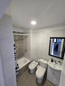 a white bathroom with a toilet and a sink at Departamento a estrenar in Godoy Cruz