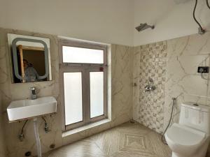 a bathroom with a sink and a toilet and a window at Sky land guest house in Leh