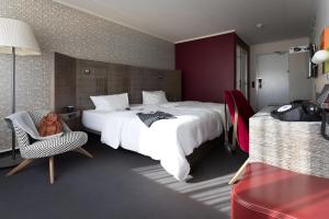a hotel room with a large bed and a chair at pentahotel Vienna in Vienna