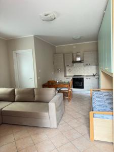 een woonkamer met een bank en een keuken bij La Porta Rossa in Biella