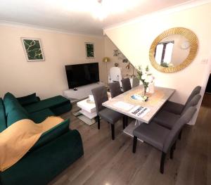 Milton Keynes 3 Bed House في Shenley Church End: غرفة معيشة مع أريكة خضراء وطاولة