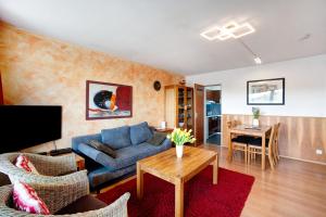 - un salon avec un canapé bleu et une table dans l'établissement Ferienwohnung Bergrose, à Obermaiselstein