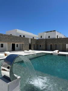 a swimming pool with a fountain in front of a building at Cavo piso livadi in Piso Livadi