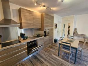 a kitchen with wooden cabinets and a table and chairs at Entre Mer et nature in Saint-Aygulf +7 photos