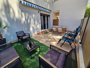 a patio with chairs and a couch and a table at Entre Mer et nature in Saint-Aygulf