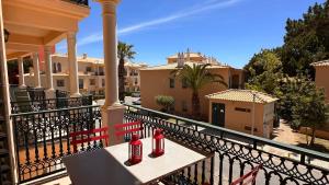 dos botellas rojas sentadas en un banco en un balcón en Bicos J by Check-in Portugal, en Albufeira