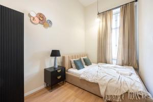 a bedroom with a bed and a window at Cozy Boulevard Apartment in the Heart of Budapest in Budapest