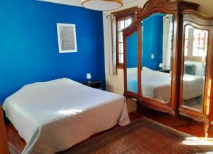 Habitación azul con cama y espejo en Apartamento de estilo en edificio patrimonial, en Montevideo