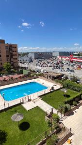 a large swimming pool in a city with a parking lot at Ole Madrid Holiday Apartament IFEMA, Aeropuerto in Madrid