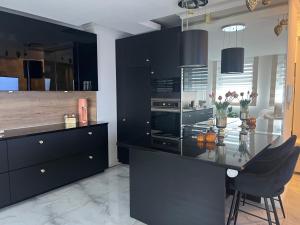 a kitchen with black cabinets and a glass table at White Lotus in Nyíregyháza